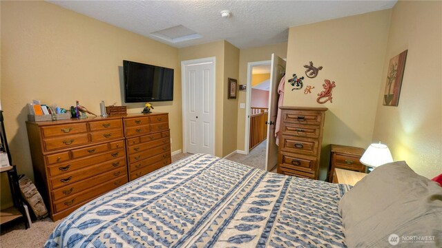 carpeted bedroom with a textured ceiling and baseboards