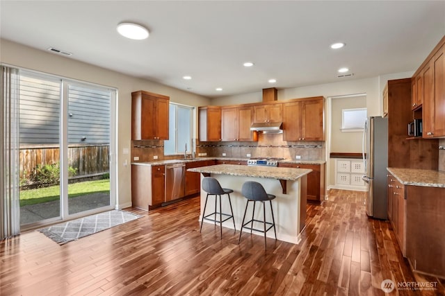 13218 106th Pl NE, Kirkland, WA 98034 - kitchen featuring appliances with stainless steel finishes, dark wood finished floors, under cabinet range hood, visible vents, and a kitchen island