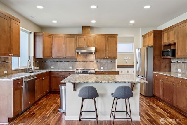 13218 106th Pl NE, Kirkland, WA 98034 - kitchen with dark wood-style flooring, appliances with stainless steel finishes, a sink, a kitchen bar, and under cabinet range hood