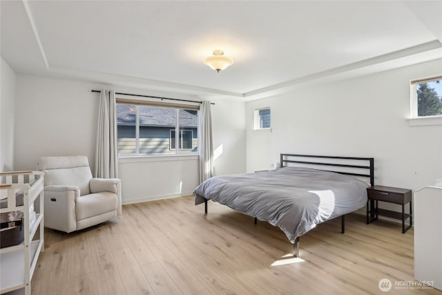 13218 106th Pl NE, Kirkland, WA 98034 - bedroom featuring baseboards, a tray ceiling, and light wood-style flooring