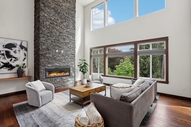 14835 NE 11th Pl, Bellevue, WA 98007 - living area featuring a towering ceiling, wood-type flooring, a stone fireplace, and baseboards