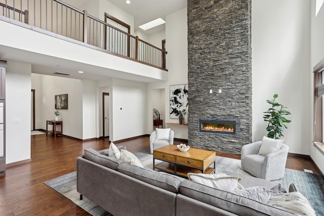 14835 NE 11th Pl, Bellevue, WA 98007 - living room featuring a towering ceiling, wood finished floors, a stone fireplace, and baseboards