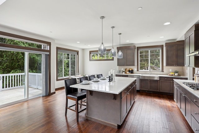 14835 NE 11th Pl, Bellevue, WA 98007 - kitchen featuring a sink, a breakfast bar, appliances with stainless steel finishes, light countertops, and backsplash