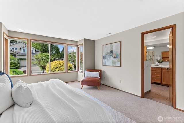 bedroom featuring light colored carpet, baseboards, recessed lighting, and ensuite bathroom