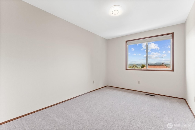 unfurnished room featuring light colored carpet and baseboards