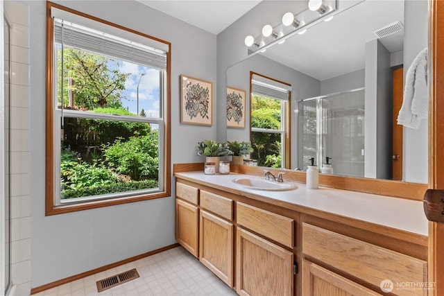 full bath with a shower stall, vanity, tile patterned floors, and baseboards