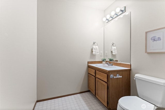 half bathroom featuring tile patterned floors, toilet, and vanity