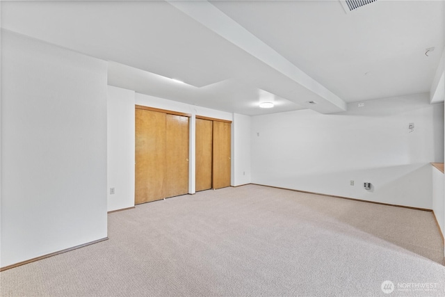 finished below grade area featuring light carpet and baseboards