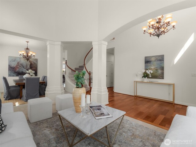 1206 S 36th Pl, Renton, WA 98055 - living room with a chandelier, decorative columns, wood finished floors, stairs, and baseboards