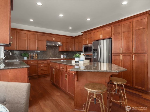 1206 S 36th Pl, Renton, WA 98055 - kitchen with appliances with stainless steel finishes, a sink, under cabinet range hood, dark wood-style flooring, and recessed lighting