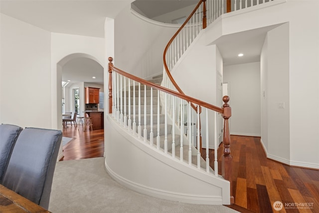 1206 S 36th Pl, Renton, WA 98055 - staircase featuring arched walkways, wood finished floors, recessed lighting, baseboards, and a high ceiling