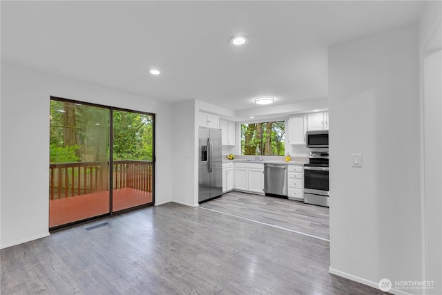 21827 4th Ave SE, Bothell, WA 98021 - kitchen with stainless steel appliances, light countertops, baseboards, white cabinets, and light wood-style floors
