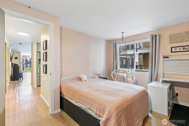 6910 California Ave SW Unit 26, Seattle, WA 98136 - bedroom with baseboards, light wood finished floors, and stainless steel fridge