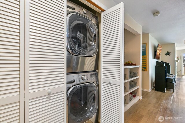 6910 California Ave SW Unit 26, Seattle, WA 98136 - laundry area with laundry area, stacked washing maching and dryer, wood finished floors, and baseboards