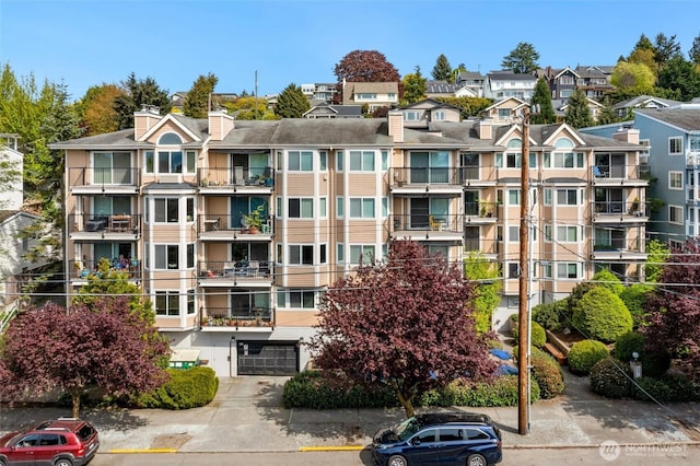 6910 California Ave SW Unit 26, Seattle, WA 98136 - view of building exterior featuring an attached garage and driveway