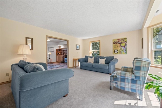living room featuring carpet floors, a textured ceiling, and baseboards