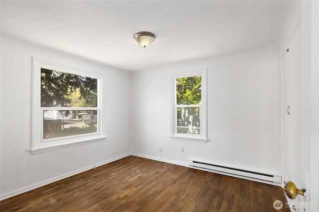 unfurnished room featuring wood finished floors, baseboards, and a baseboard heating unit
