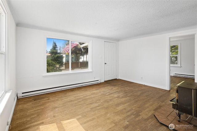 unfurnished living room with baseboards, a baseboard radiator, a textured ceiling, and wood finished floors