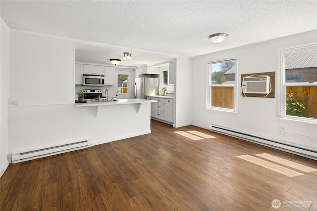 unfurnished living room with an AC wall unit, a textured ceiling, baseboard heating, and dark wood-style floors