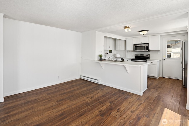 kitchen with a kitchen breakfast bar, stainless steel appliances, a peninsula, dark wood-type flooring, and a baseboard heating unit