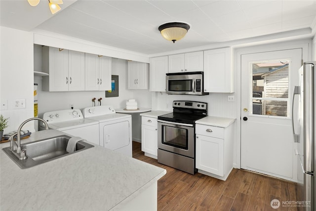 kitchen featuring separate washer and dryer, a sink, dark wood-style flooring, and appliances with stainless steel finishes