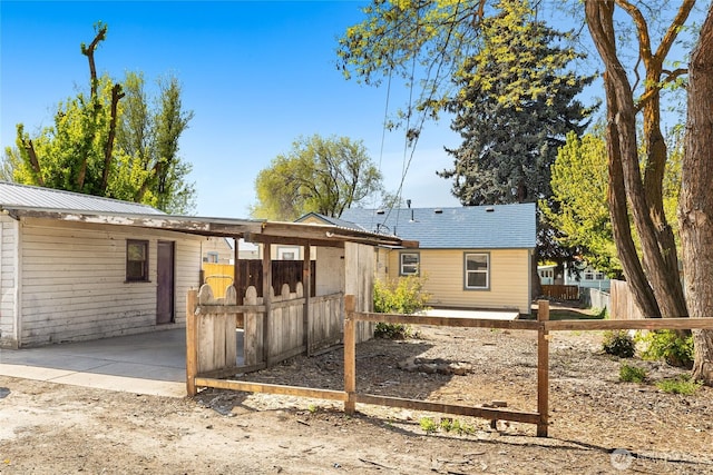 rear view of house with fence and a patio area