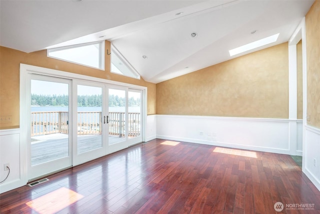 1407 Creso Rd S, Spanaway, WA 98387 - unfurnished room featuring lofted ceiling with skylight, hardwood / wood-style flooring, and wainscoting