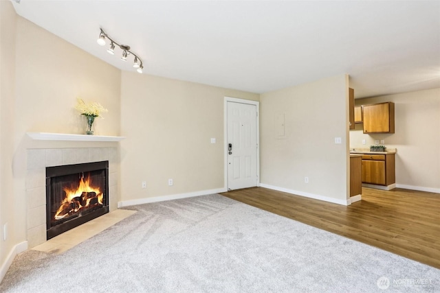 16817 Larch Way Unit B202, Lynnwood, WA 98037 - unfurnished living room with carpet floors, baseboards, wood finished floors, and a fireplace