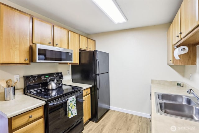 16817 Larch Way Unit B202, Lynnwood, WA 98037 - kitchen featuring a sink, light countertops, black appliances, and light wood finished floors