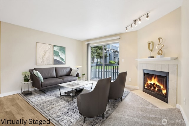 16817 Larch Way Unit B202, Lynnwood, WA 98037 - living area featuring baseboards, wood finished floors, rail lighting, and a fireplace