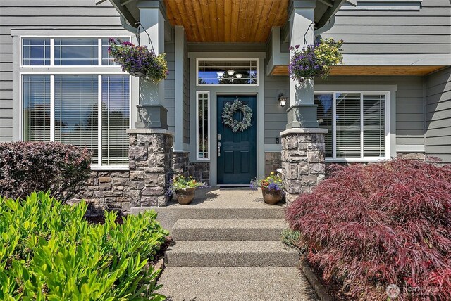13211 174th St E, Puyallup, WA 98374 - view of exterior entry with stone siding and a porch