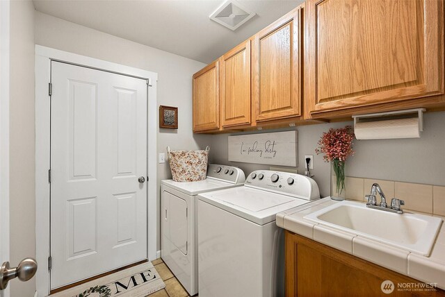 13211 174th St E, Puyallup, WA 98374 - washroom with cabinet space, washer and clothes dryer, and light tile patterned floors