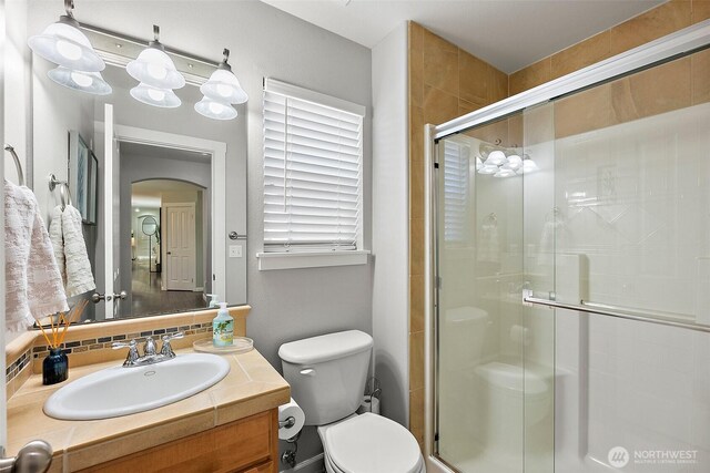 13211 174th St E, Puyallup, WA 98374 - bathroom featuring a shower stall, toilet, vanity, and tasteful backsplash