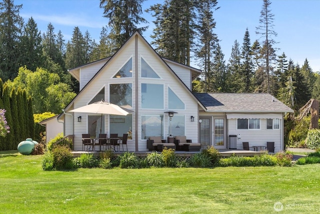 rear view of house with a deck, a yard, and outdoor lounge area