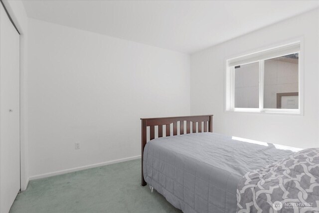 bedroom with carpet floors, baseboards, and a closet