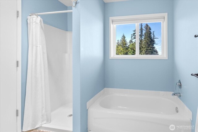 bathroom featuring a stall shower and a bath