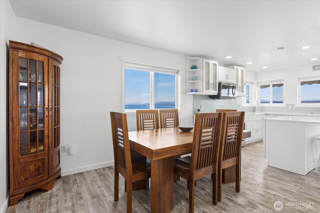 dining room with light wood-style floors, plenty of natural light, recessed lighting, and baseboards