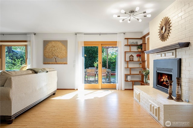 604 128th Ave SE, Bellevue, WA 98005 - living room featuring a brick fireplace, light wood-style flooring, and a chandelier