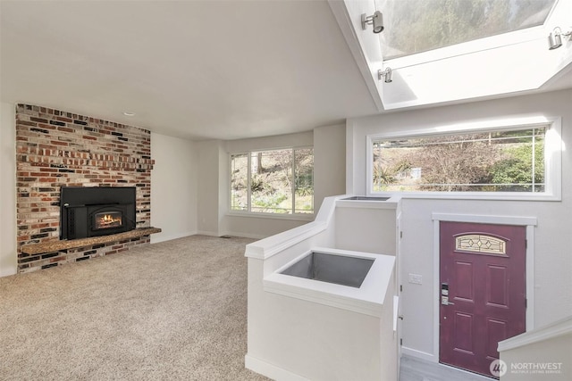 carpeted entrance foyer with baseboards and a fireplace