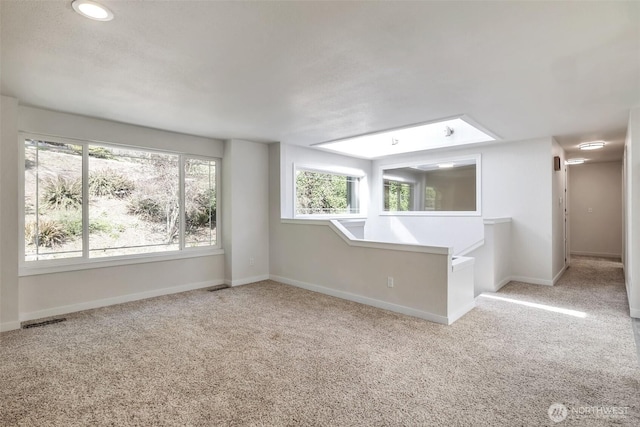 carpeted empty room with baseboards and visible vents