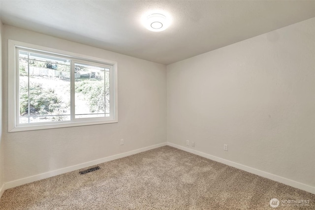 carpeted empty room with baseboards and visible vents