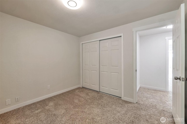 unfurnished bedroom featuring carpet flooring, baseboards, and a closet