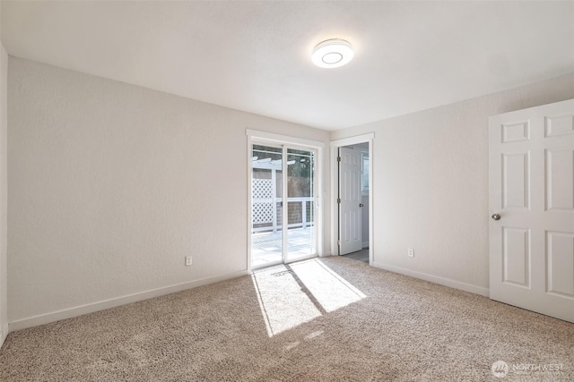 unfurnished bedroom featuring baseboards, access to exterior, and carpet