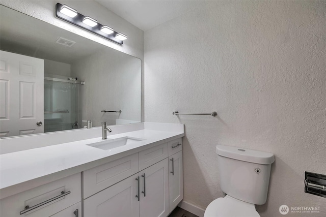 full bathroom featuring an enclosed shower, toilet, a textured wall, and visible vents