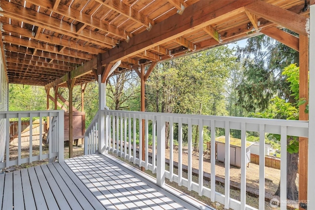 wooden deck featuring an outdoor structure and a shed