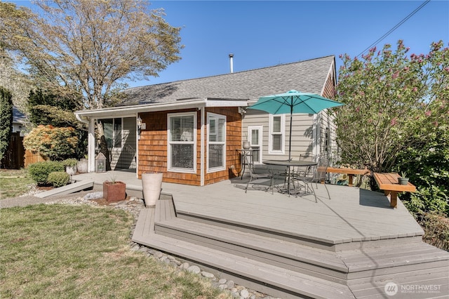wooden deck featuring fence, outdoor dining space, and a yard