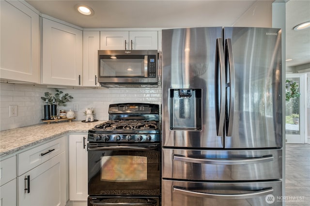 kitchen with tasteful backsplash, light stone countertops, recessed lighting, stainless steel appliances, and white cabinetry