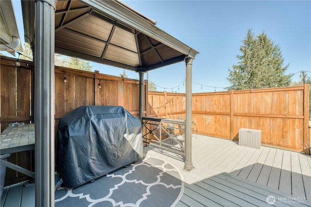 deck featuring a gazebo, grilling area, and fence