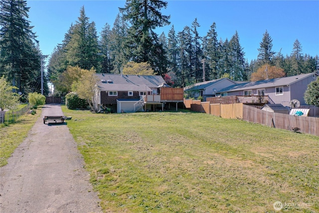 view of yard featuring a deck, stairs, and fence