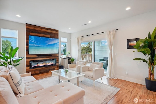 living room with recessed lighting, visible vents, and wood finished floors